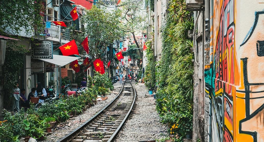 Hanoi, Vietnam train tracks, flags, and graffiti.