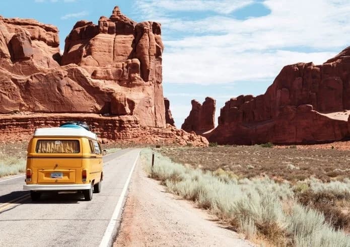camper van on a road winding through beautiful rocky landscape