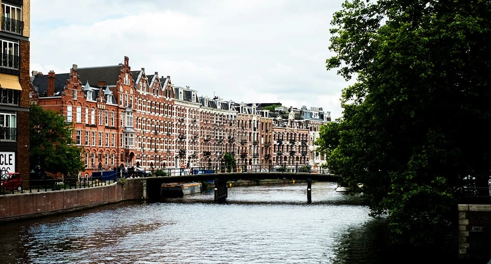 Buildings along river in fall in Amsterdam.