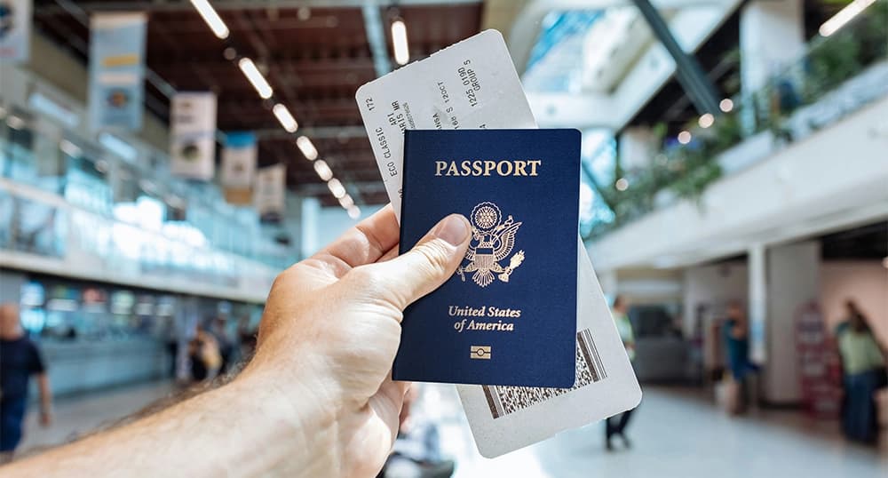 Passport and boarding pass held up in an airport.