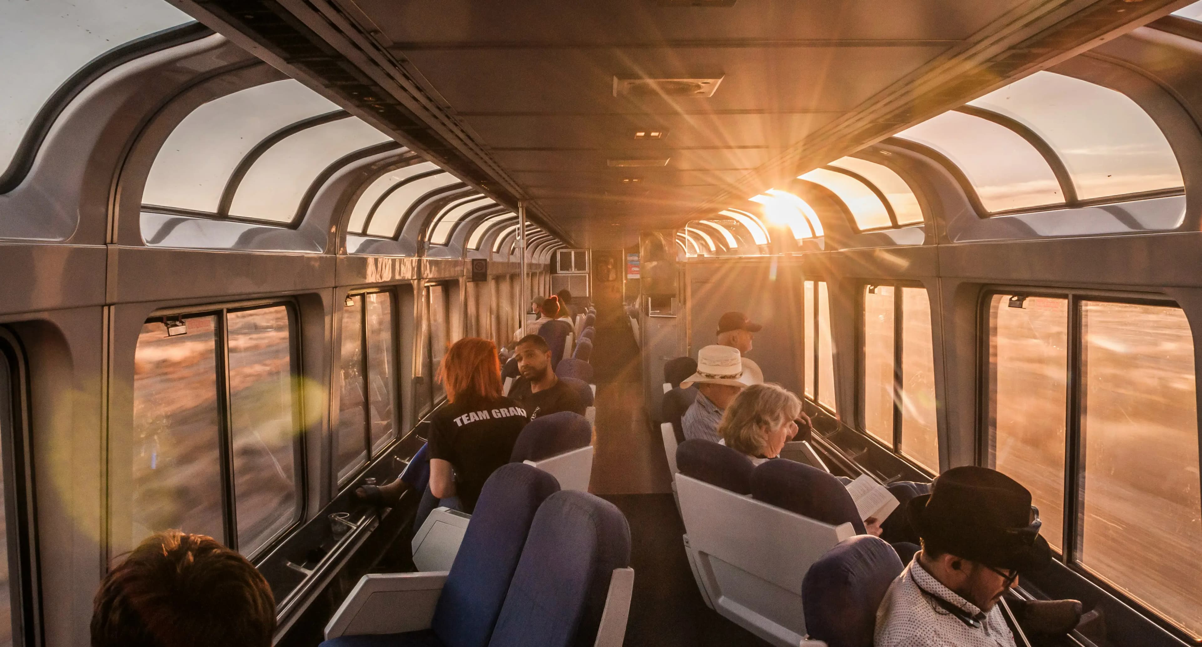 People on sitting on a glass roof train watching the sunset by Daphne Fecheyr on Unsplash