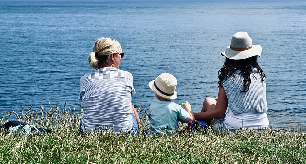 Generational family sitting and enjoying the ocean view.