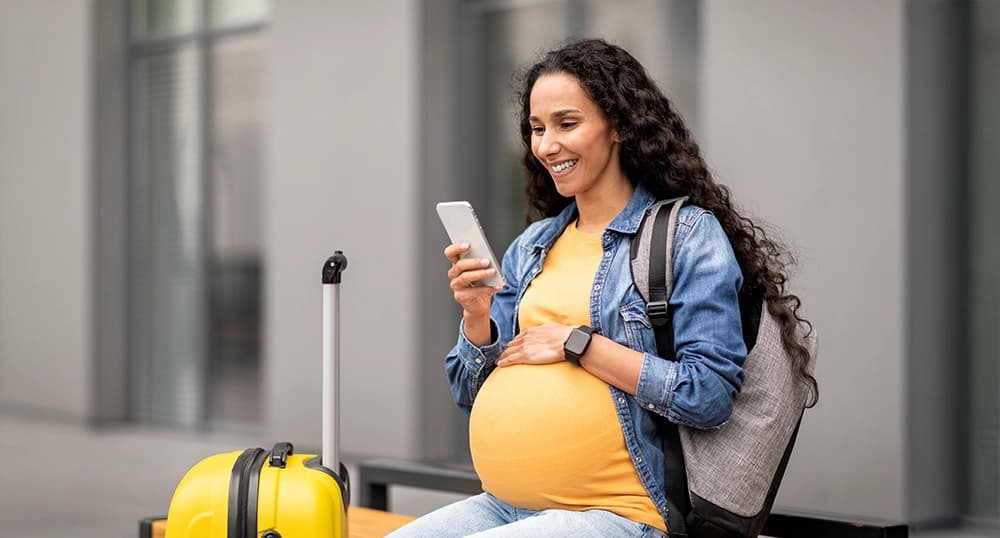 Pregnant woman checking in at airport.