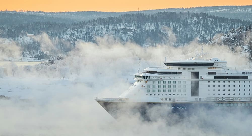White cruise ship on ice on a foggy winter morning.