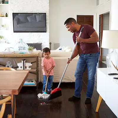 Man cleaning his house with his son before they leave on a vacation.