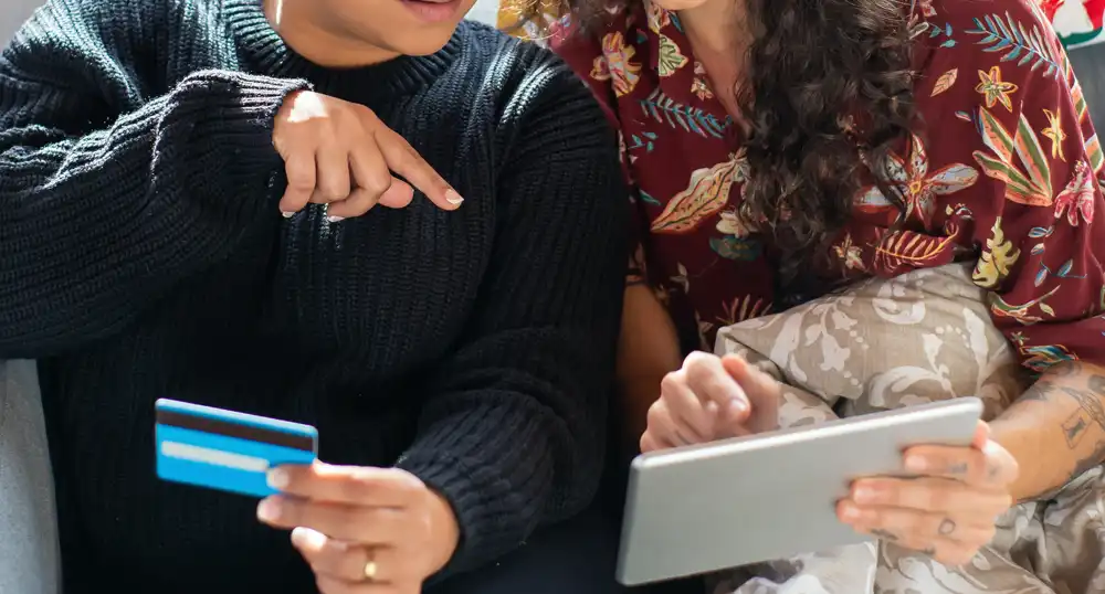 Two women make an online purchase with credit card.