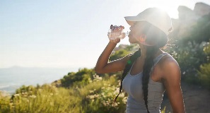 Woman exploring a new city by hiking, and takes a sip of water.