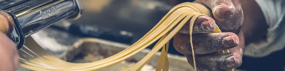 Making fresh fettuccine pasta in an Italian market.