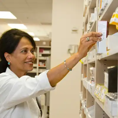 Pharmacist puts medication on a shelf