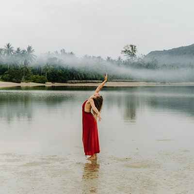 a woman in a red dress standing in the water