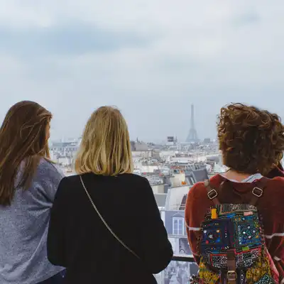 Three young women overlook Paris with Eiffel Tower