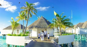 Family leaving over-water bungalows in Maldives.