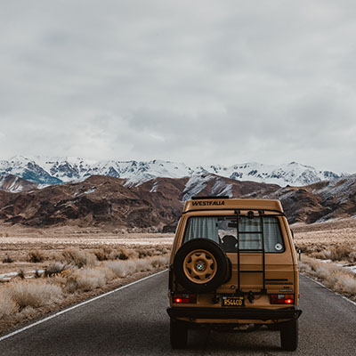 Van driving down a road with view of mountains.