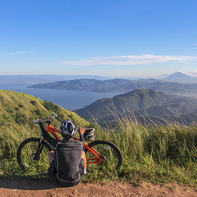 Man overlooking beautiful view with his bike.