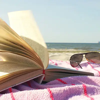 Reading a book on the beach.
