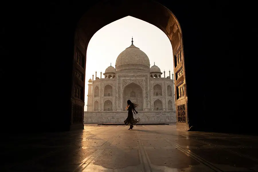 Woman dancing in front of Taj Mahal in India.