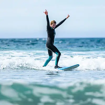 Woman surfer celebrating after surfing through a tough wave.