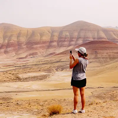 Woman taking pictures in desert.