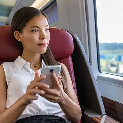 Woman on first class flight looking at apps on her cell phone.
