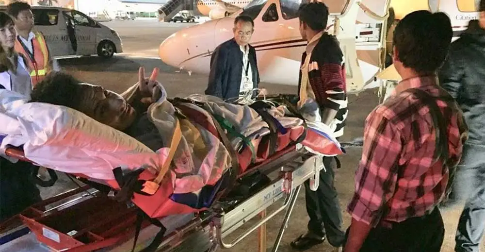 EMT helping man on stretcher in Southeast Asia