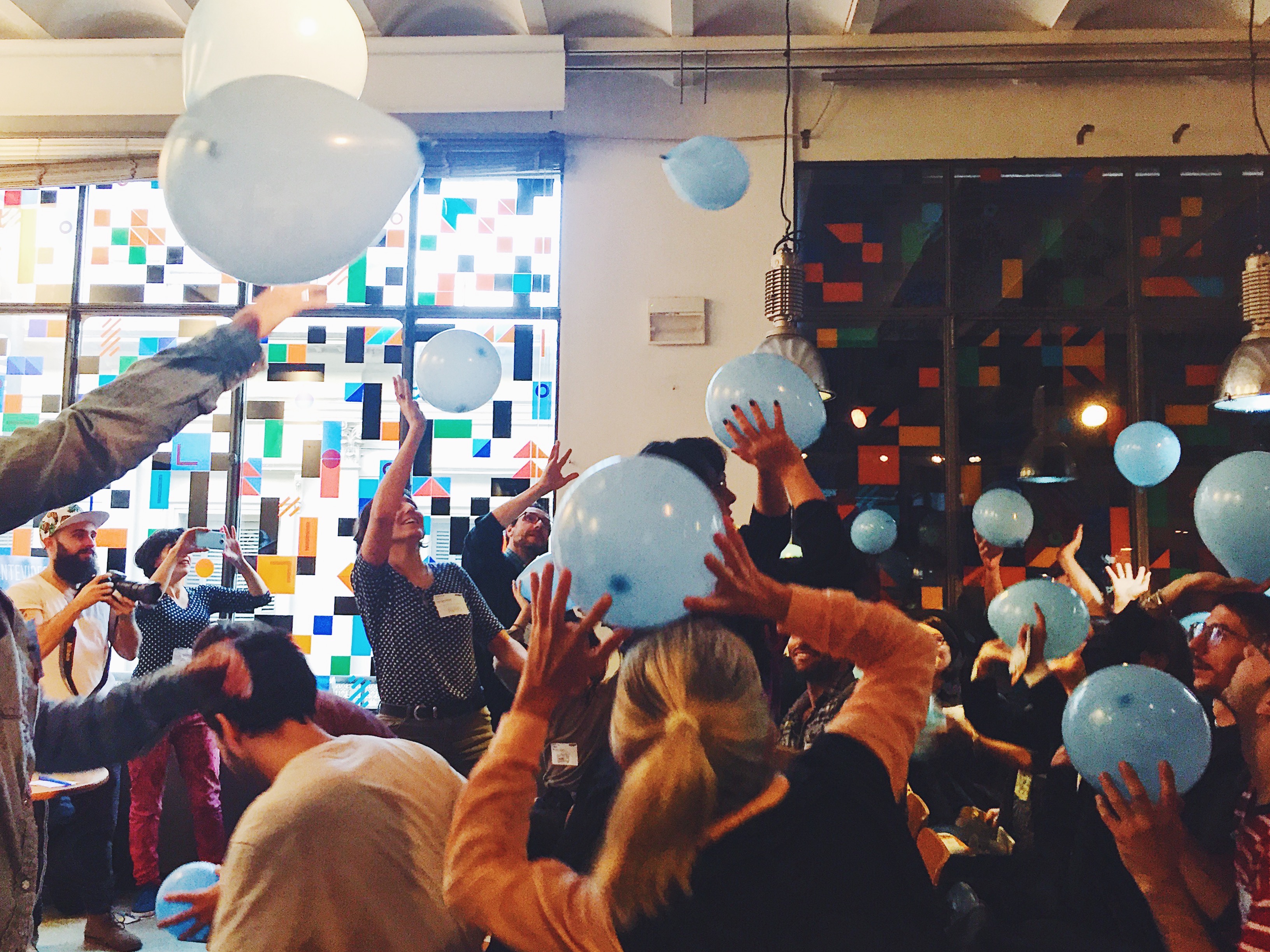 Group-of-adults-throwing-blue-balloons-up-in-air