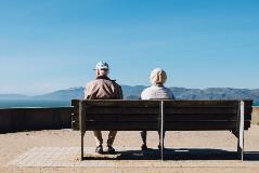 Baby-boomer-travelers-sit-on-bench-during-vacation